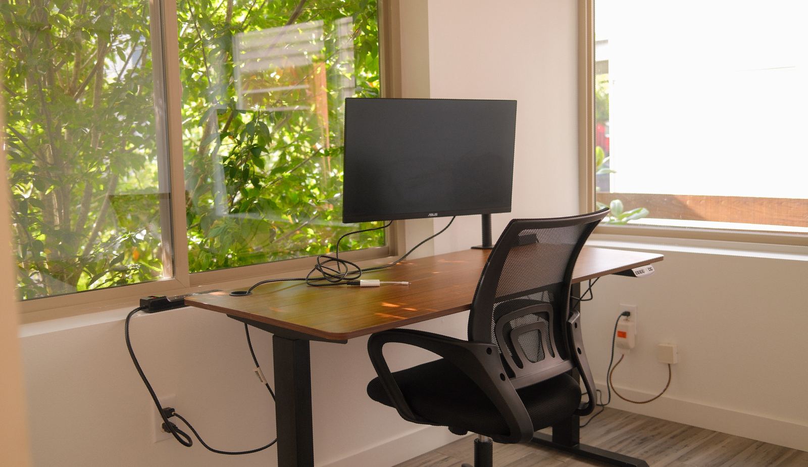 Standing desk with external monitor by the window